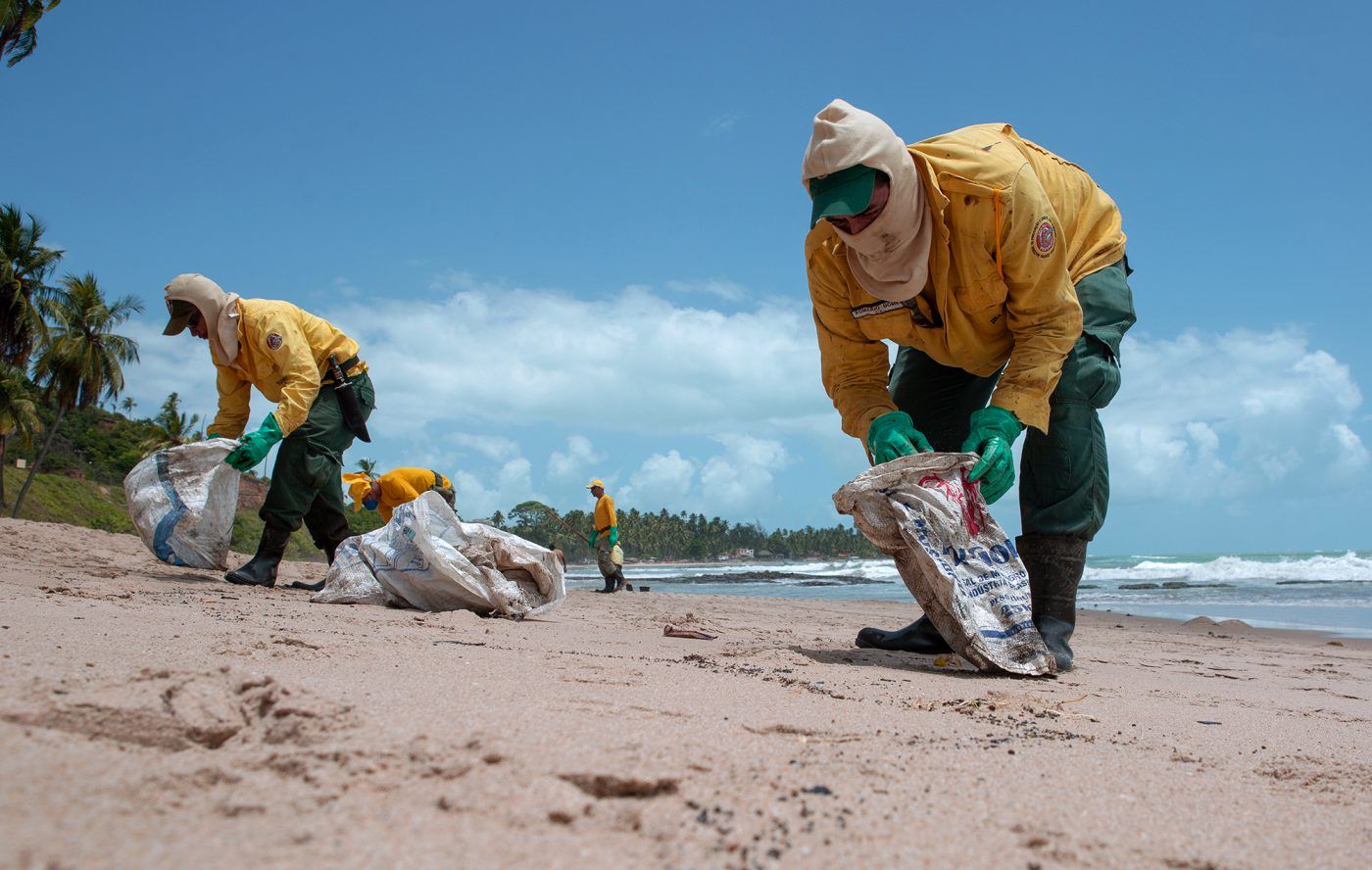 Empleados del gobierno brasileño limpian el petróleo de la playa de Japaratinga, en el estado de Alagoas. Crédito: Léo Malafaia/Diálogo Chino